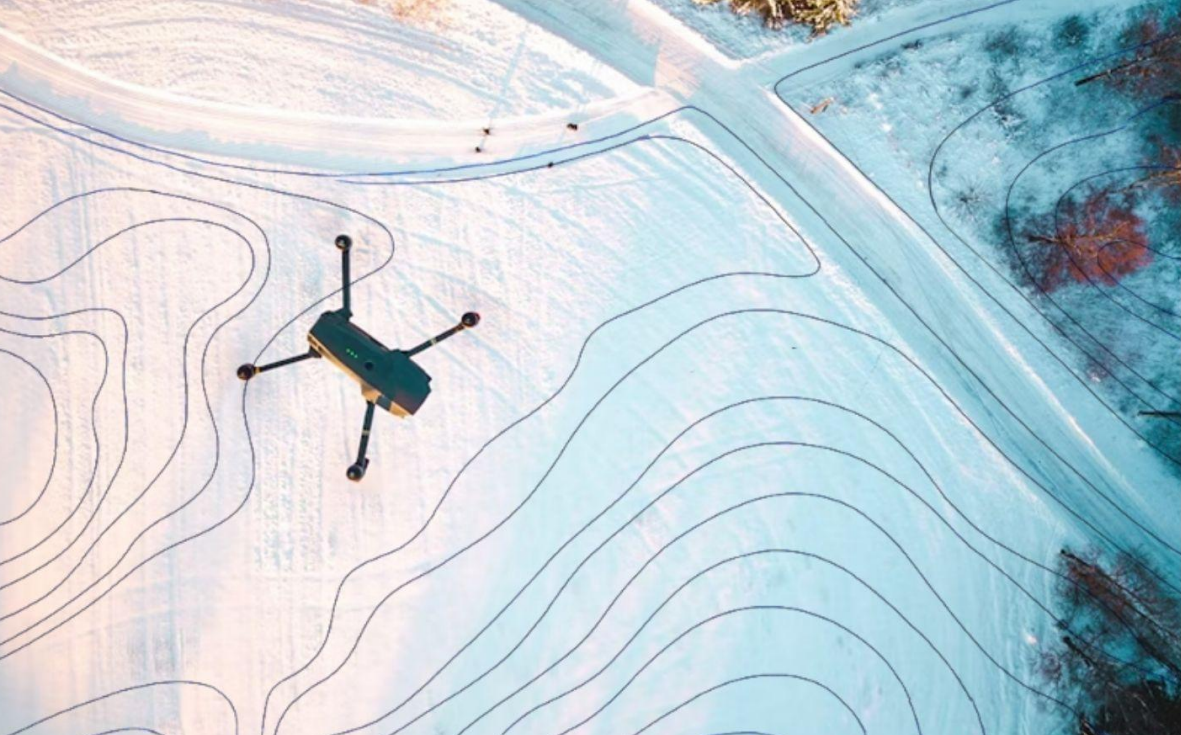 Abbildung einer Drohne, die über eine Blicke fliegt und dabei Bilddaten sammelt.