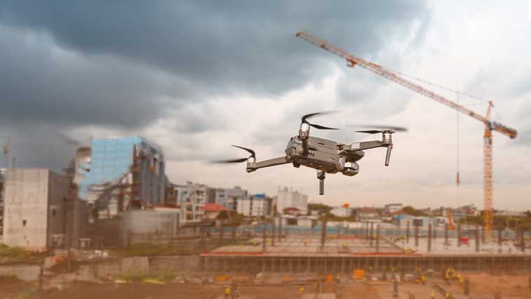 Eine Drohne am bewölkten Himmel über einer Baustelle-