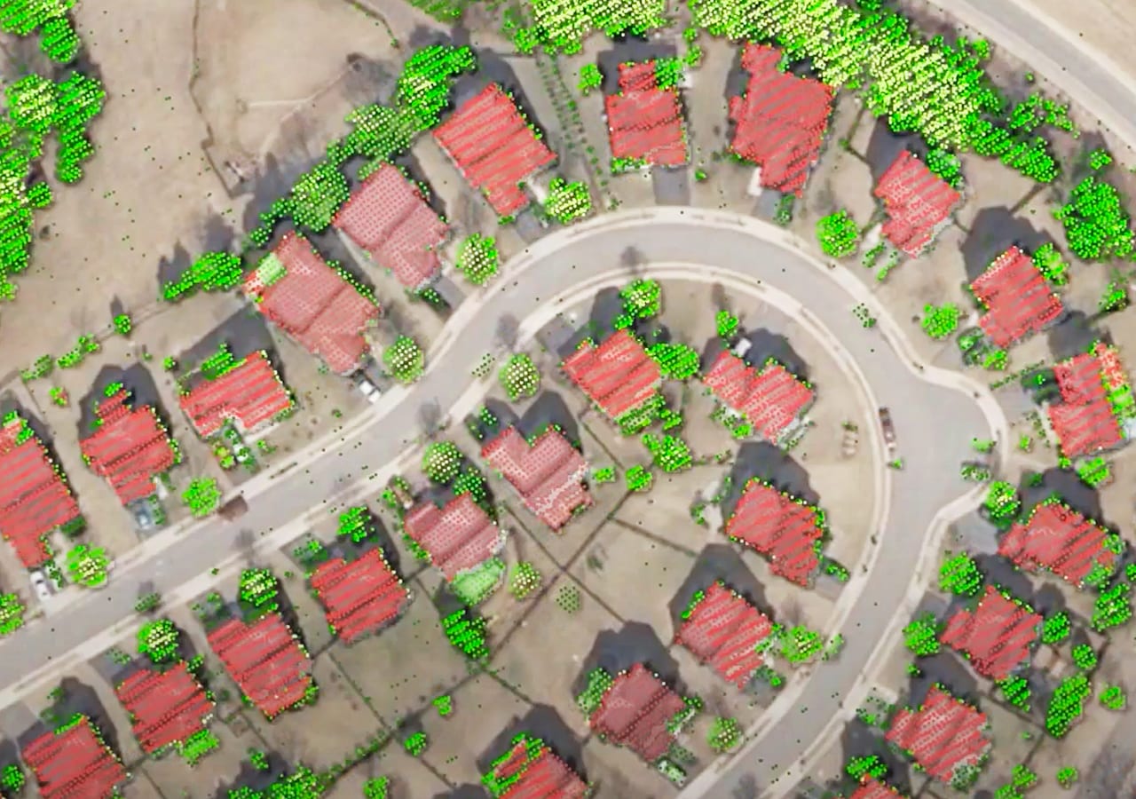Auf einem Luftbild eines Wohnviertels sind die Gebäude rot und die Bäume grün hervorgehoben