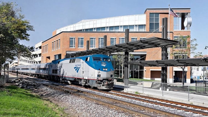 Bild eines blau-weißen Zuges, der einen Bahnhof verlässt