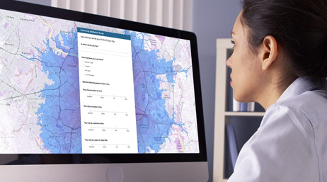 Frau, die sich eine große Karte auf einem Computermonitor anschaut