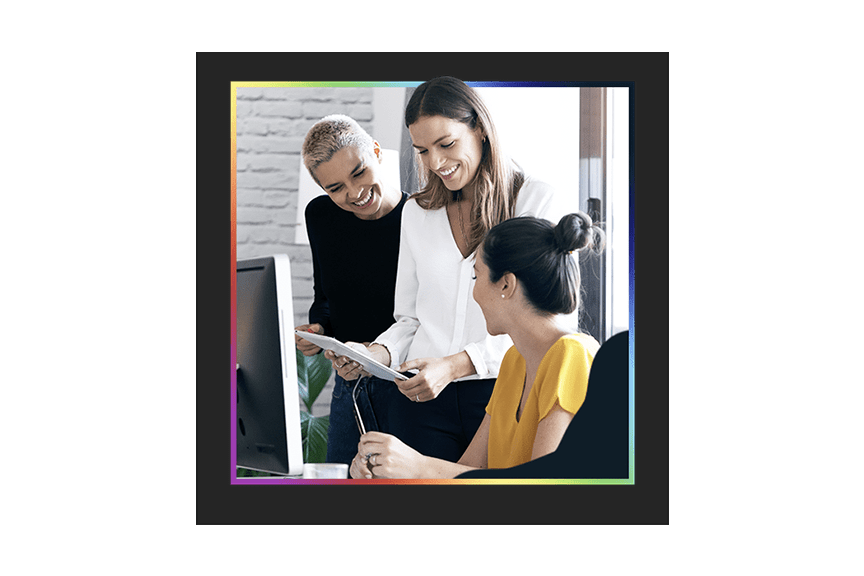 An expert working with two office workers to optimize the use of technology