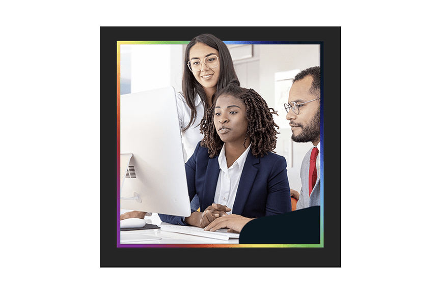 Two consultants helping a business person with their computer 