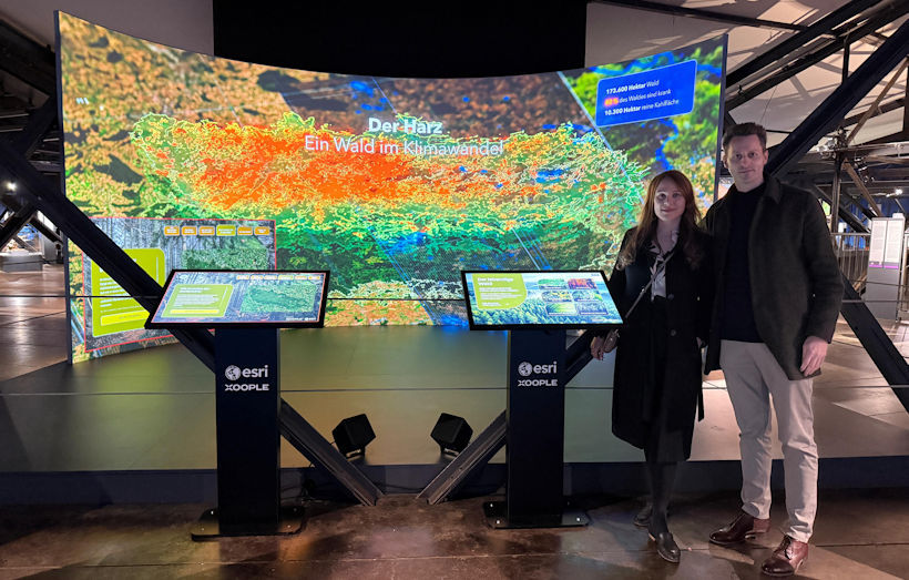 Annika Schindler und Bernd Weißner von Esri Deutschland vor dem interaktiven Exponat von Esri im Gasometer Oberhausen.